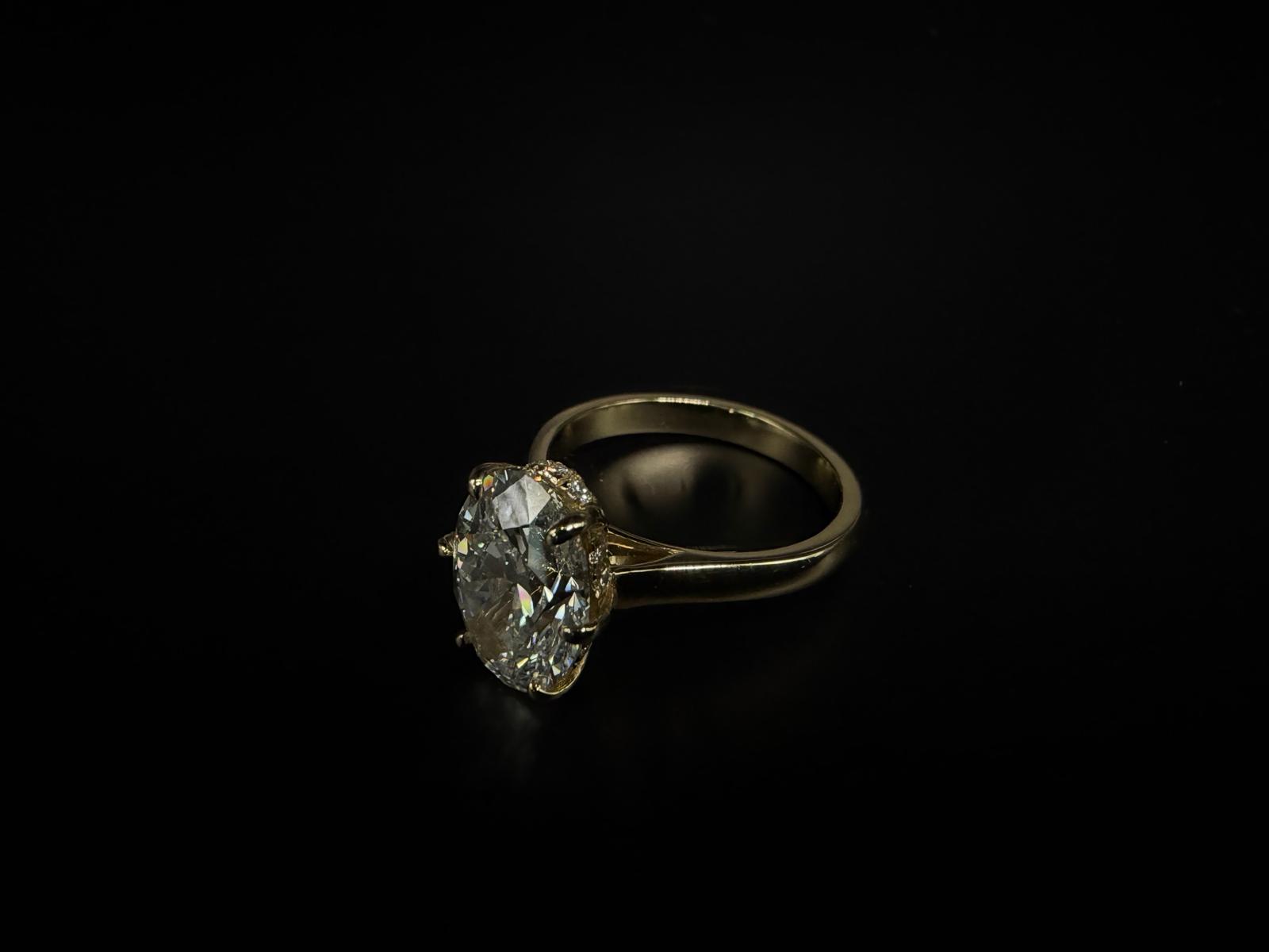 An oval centre stone with a hidden halo beneath the setting.